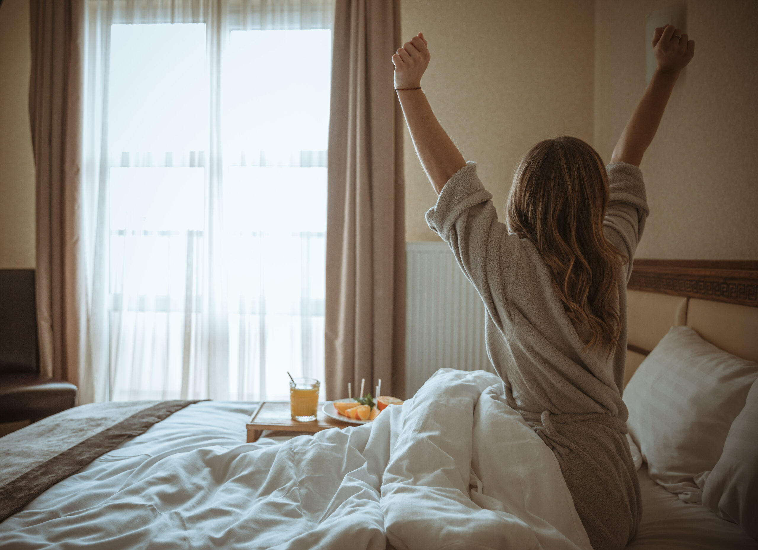 rear-view-woman-stretching-body-after-awakening-bed